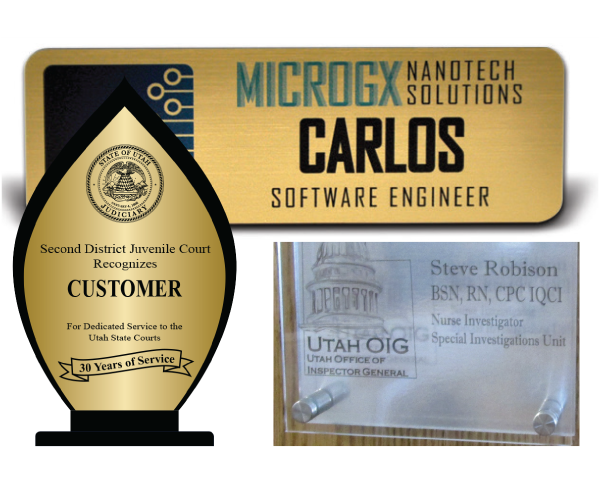 Two metal gold signs with lettering and one glass sign with lettering and image of the capitol on a wood object.