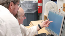 Inmate teaching another inmate on the computer