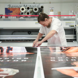Inmate working on large poster print at the print shop