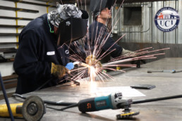 Inmates operating welding equipment to weld metal together
