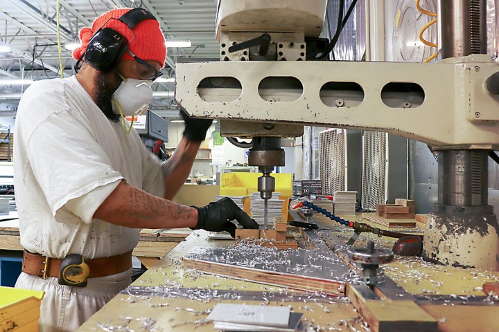 Incarcerated individual working on a sign
