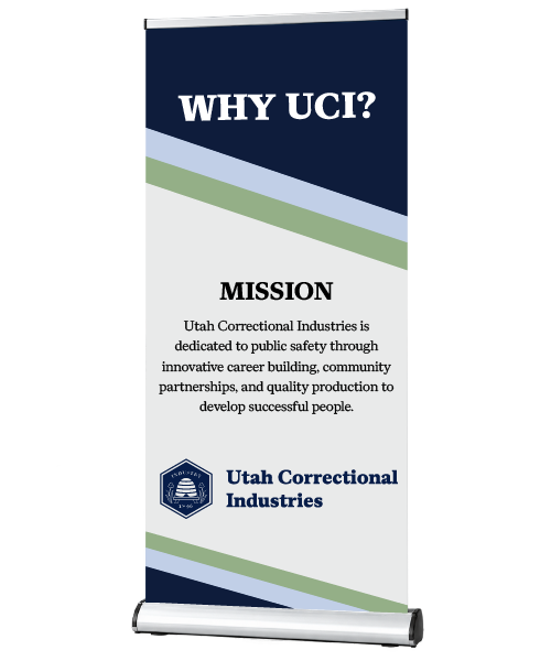 A pop up banner for Utah Correctional Industries representing the mission statement, UCI logo, and color scheme (Navy Blue, Mist Blue, and Sage). Banner is held in a silver stand.